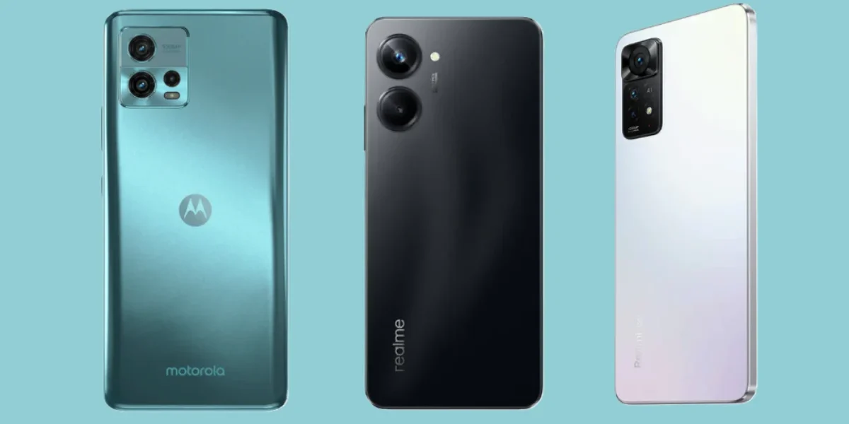 Three budget smartphones side by side: Motorola in teal, realme in black, and Redmi in white, showcasing rear designs and camera modules on a blue background.