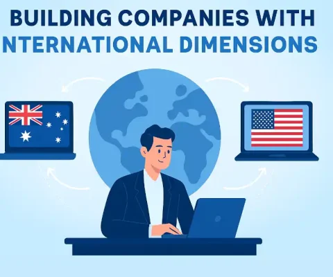 Strategic Wealth Building Illustration Of A Professional Managing International Company Operations With Laptops Displaying Australian And American Flags Connected Via A Global Network.