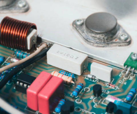Close-Up Of Led Power Supply Circuit Board Showing Copper Coil, Resistor, Capacitors And Electronic Components