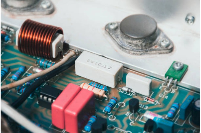 Close-up of LED power supply circuit board showing copper coil, resistor, capacitors and electronic components