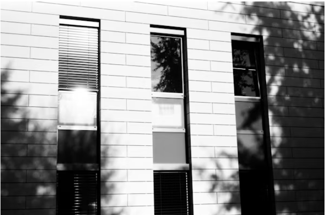 Modern white brick building with architectural window films and privacy treatments