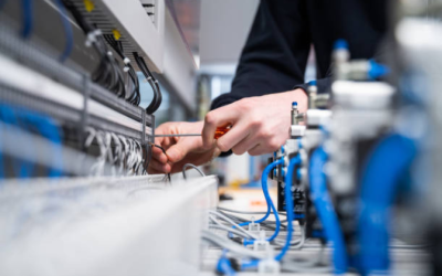 Technician Installing Dc Surge Protector In Industrial Electrical Panel With Blue Components And Wiring