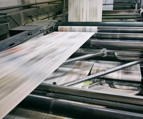 Flexo Printing Equipment In Action, Showing High-Speed Paper Feed Through Rollers With Multicolor Ink For Industrial Packaging Production.