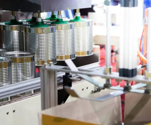 Automated Tin Can Sealing Machine Applying Lids To Multiple Metal Cans On A Production Line.