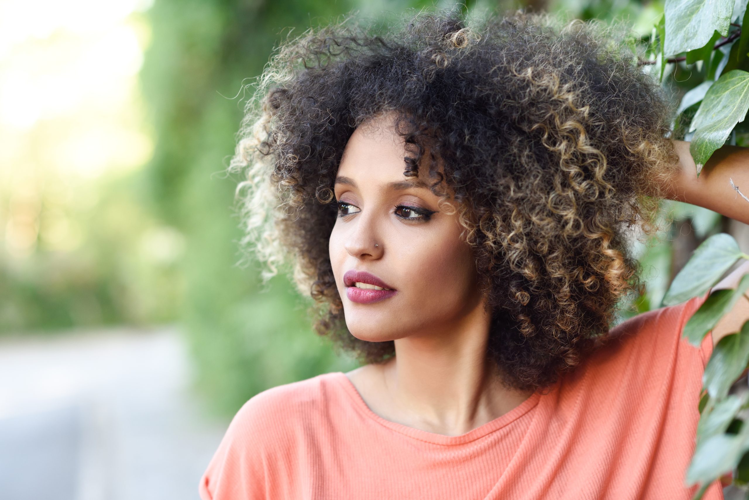 Woman with defined curly hair styled in professional updo for work