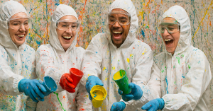 Why Choos Splatter Rooms for Corporate Events Bay Area? 1 Group in protective gear enjoying paint splatter activity for corporate team building